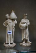 A pair of Royal Worcester figures of the Cairo Water Carriers, modelled by James Hadley in blush