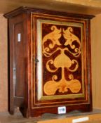 A 20th Century mahogany wall cabinet with stained wooden door, painted marquetry design, 35.5cm