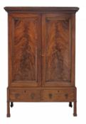 A late George III flame mahogany cupboard, circa 1800 and later, the caddy topped dentil cornice