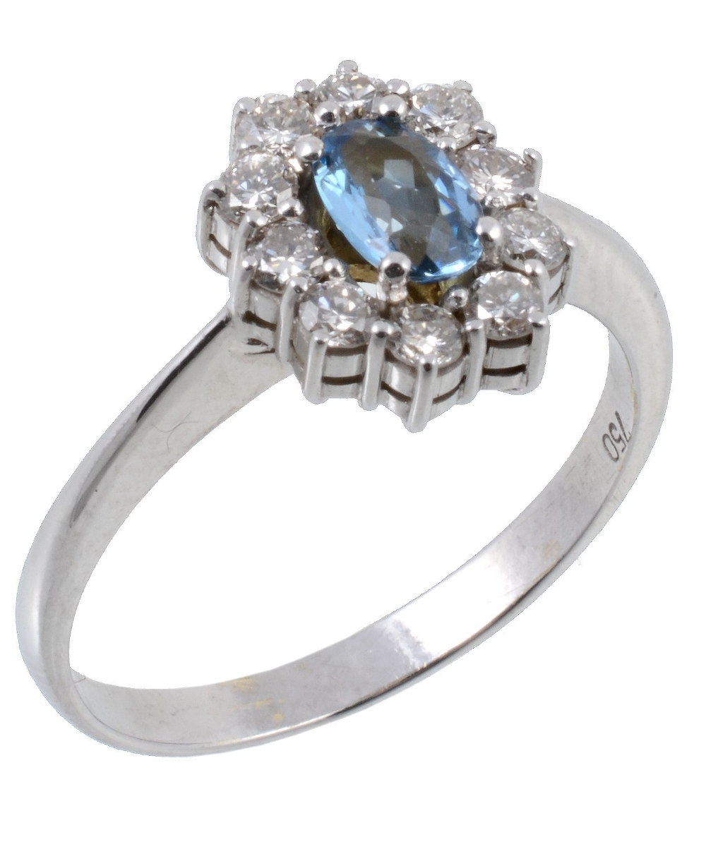 An aquamarine and diamond cluster ring, the central oval shaped aquamarine...  An aquamarine and