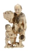 A Japanese Ivory Okimono Group   of a fisherman and his son, the former holds a net in one hand and