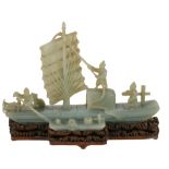 A jadeite model of a junk, 20th century, carved with three sailors on deck and a dog, the vessel