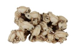 An ivory netsuke in the style of Mitsumasa, 19th century  , carved as a mass of small frogs upon a