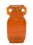 A small flattened amber vase, 18th century  , with twin mythical beast head handles, finely