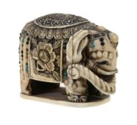 A Japanese Ivory Okimono of a Caparisonned Elephant,   the creature stands four-square of a rounded