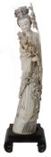 A large ivory figure of Guanyin, first third of the 20th century  , holding flowering peony branch,