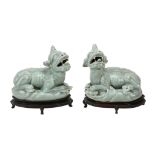 A pair of Chinese celadon mythical beasts,   each recumbent facing to the left and right, with open