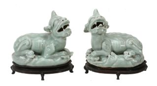 A pair of Chinese celadon mythical beasts,   each recumbent facing to the left and right, with open