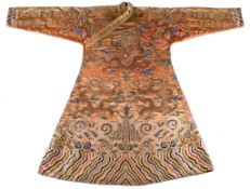 A coral ground silk Tibetan chuba, tailored from 18th century Chinese  kesi  , featuring eight