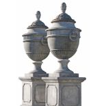 A pair of Continental carved limestone garden urns and covers, on pedestals  A pair of Continental