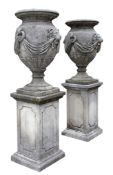 A pair of french carved limestone urns on pedestals, early 20th century A pair of french carved