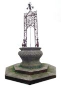 A carved limestone and wrought iron mounted wellhead  A carved limestone and wrought iron mounted