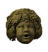 A sculpted limestone wall fountain mask of the infant Bacchus, 20th century  A sculpted limestone