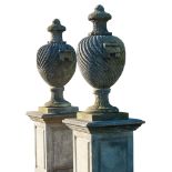 A pair of French carved limestone urns and covers, on pedestals, 20th century  A pair of French