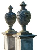 A pair of French carved limestone urns and covers, on pedestals, 20th century  A pair of French