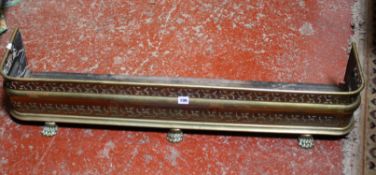 A Victorian pierced brass fender with paw feet 113cm length, plus a brass club fender, a cartouche