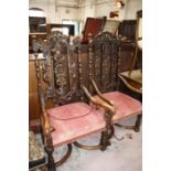 A near pair of Carolean style carved walnut open armchairs each with profusely carved back,