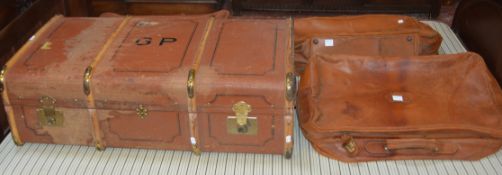 A canvas and brass mounted travelling trunk, together with three leather suitcases (4)