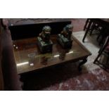 A lacquered top Chinese style low table and a pair of glazed ceramic Dogs of Fo.