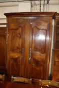 A large18th century Normandy cherrywood armoire with moulded cornice and panelled doors raised on