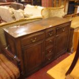 A George II style oak dresser base with drawers and two cupboard doors 140cm wide