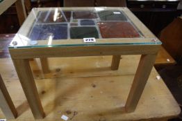 A small Japanese oak  table with 16ml hardened glass top with leaded light insert