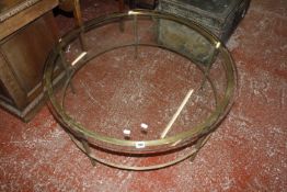 A circular glass topped coffee table 97cm diameter