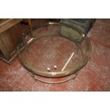 A circular glass topped coffee table 97cm diameter