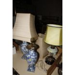 A pair of blue and white pottery vases, adapted as lamps (one AF) and an oil lamp adapted for