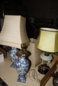 A pair of blue and white pottery vases, adapted as lamps (one AF) and an oil lamp adapted for