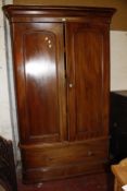 A Victorian mahogany wardrobe with a fitted interior of drawers and shelves,arch panelled doors over