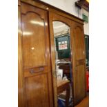 An Edwardian single mirror door wardrobe flanked by two panelled doors.150cmwide x 210cm high.