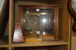 A set of cabinet balance scales in glazed cabinet, a metronome and a cased of weights (3)