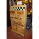 A pine wine rack with tiled back and drawers above a pair of cupboards .