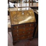 A Georgian style walnut bureau with four long drawers on bracket feet 62cm wide