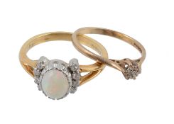 An 18 carat gold diamond and opal ring, the oval cabochon opal between two...  An 18 carat gold
