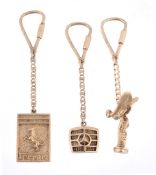 Three 9 carat gold key fobs , two in the form of car badges  Three 9 carat gold key fobs  , two in