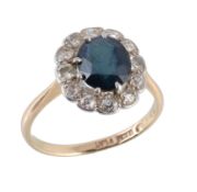 A sapphire and diamond cluster ring, the oval cut sapphire within an old cut...  A sapphire and