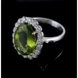 A peridot and diamond cluster ring, the central oval shaped peridot claw set...  A peridot and
