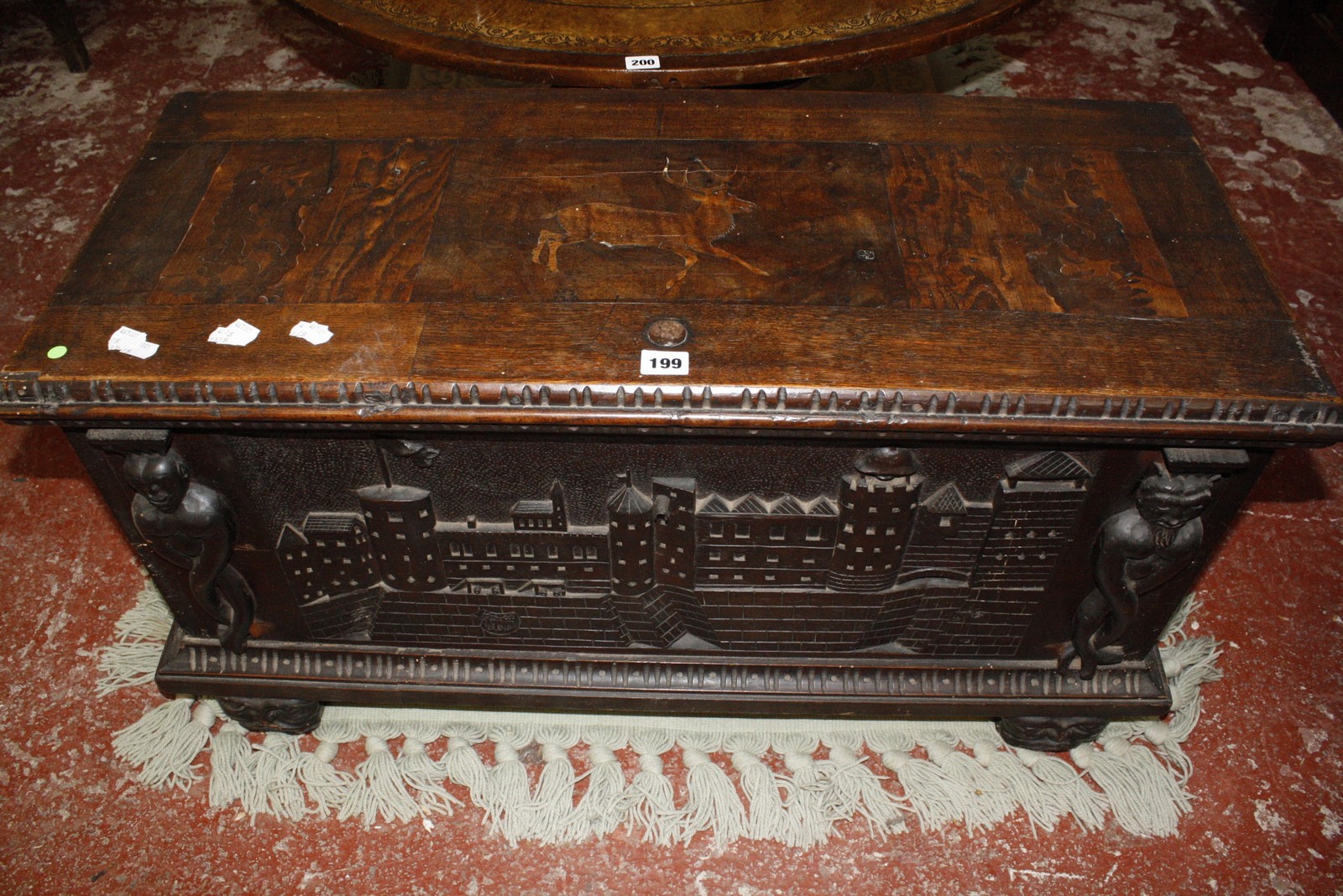 A Continental 19th Century blanket box, the top inlaid with a stag and the front with carved