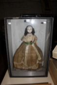 A wax head doll in Victorian dress, in wooden and glazed display case, 68cm x 46cm