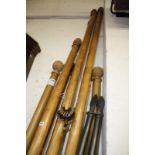 Eight assorted stained wood and metal curtain poles, the longest 210cm