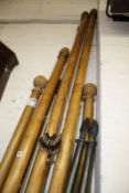 Eight assorted stained wood and metal curtain poles, the longest 210cm