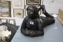A modern composition sculpture of a girl lying on her front, with Chinese seal mark to the side,