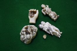 Four Japanese Netsuke groups, a man carrying a young boy, a hand holding a monkey, a fruit seller