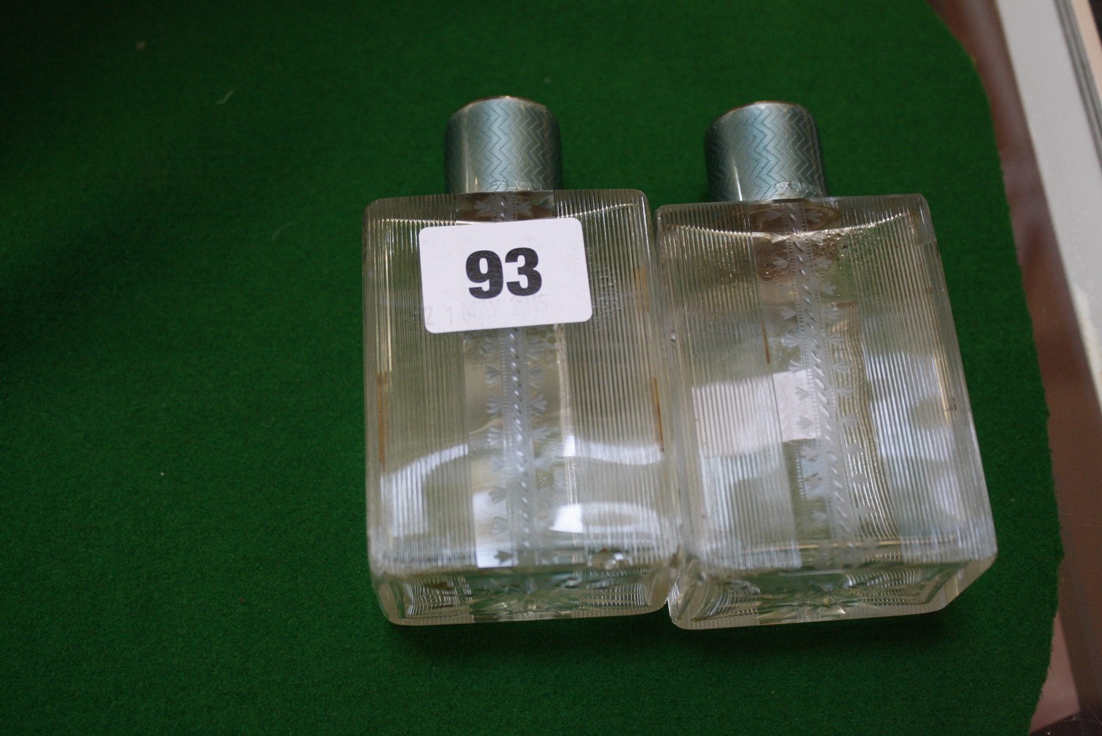 A pair of Art Deco glass perfume bottles with silver and green enamel lids, Birmingham 1931