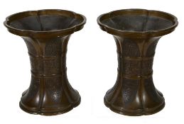 A pair of bronze archaic style vases,   the five lobed bodies with flared foot and rim with lappet
