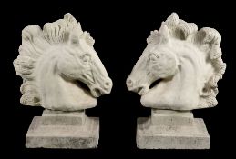 A pair of reconstituted stone pier finials modelled as horses' heads  A pair of reconstituted
