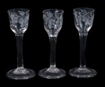 A set of three engraved plain-stemmed wine glasses, mid 18th century  A set of three engraved