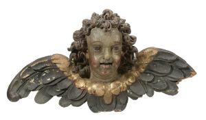 An Italian carved, painted and parcel giltwood winged cherub head  An Italian carved, painted and